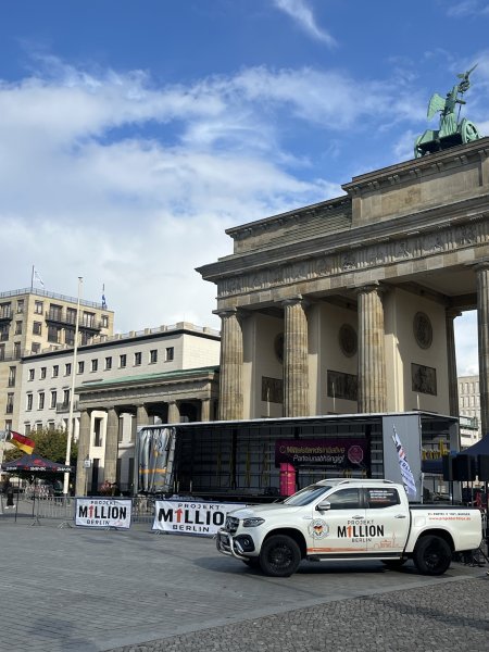 leere B&uuml;hne und Auto vor dem Brandenburger Tor. Beide mit der Aufschrift "Projekt M1llionen". Keine Menschen zu sehen